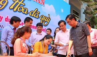 Ông Nguyễn Đức Chính (bìa phải ảnh) - Chủ tịch UBND tỉnh Quảng Trị ủng hộ kinh phí cho ban tổ chức để thực hiện con đường hoa dã quỳ. Ảnh: Hưng Thơ.