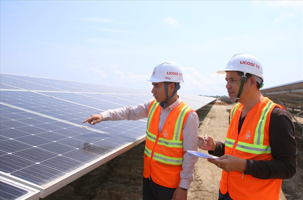 Tác giả (phải) trên công trường cánh đồng điện mặt trời tại xã Gio Hải (huyện Gio Linh, Quảng Trị). Ảnh: HƯNG THƠ