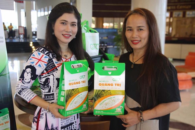 Chị Phạm Thị Diễm Lệ (trái) và sản phẩm Gạo hữu cơ Quảng Trị. Ảnh: QTO