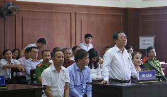 Doanh nhân Trương Huy Liệu (áo trắng, đứng) bị cáo buộc tội buôn lậu gỗ trắc trong vụ án kéo dài gần 9 năm. Ảnh: Hưng Thơ