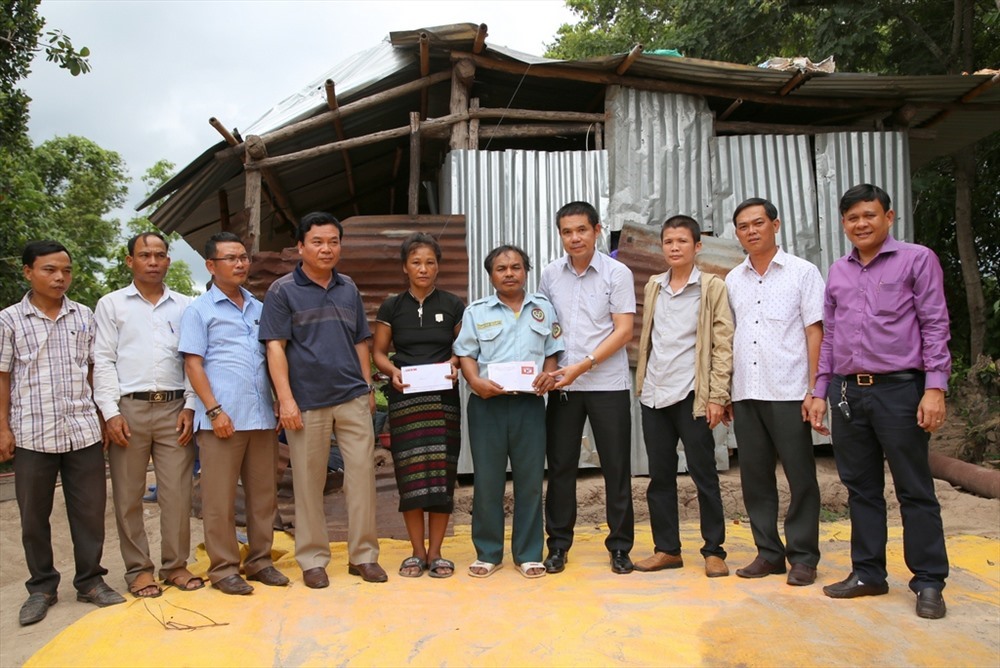 Đại diện Quỹ Tấm Lòng vàng Lao Động, Ủy ban Mặt trận Tổ Quốc Việt Nam huyện Hướng Hóa, chính quyền địa phương và các doanh nghiệp hỗ trợ tiền cho gia đình ông Xé. Ảnh: Hưng Thơ.