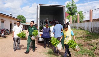 Cán bộ, chiến sĩ và người dân tặng cây giống cho người dân nước bạn Lào. Ảnh: TH.