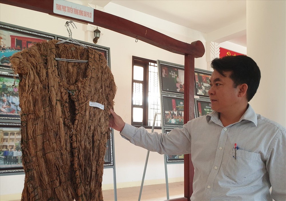 Ông Hồ Văn Phương và chiếc áo A Mưng trưng bày ở nhà văn hóa các dân tộc thiểu số. Ảnh: Hưng Thơ.