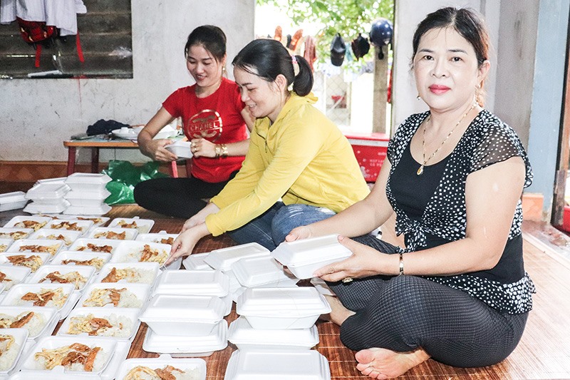 Hội viên Hội Phụ nữ thị trấn Cam Lộ chuẩn bị các suất ăn cho người dân vùng lũ - Ảnh: T.P​