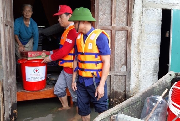Hội Chữ thập đỏ Quảng Bình hỗ trợ người dân vùng bị ngập lụt. Ảnh: QDND  Các nhân viên c