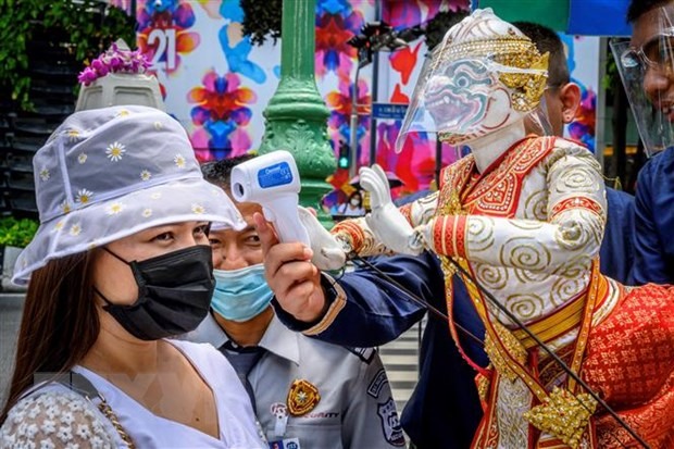 Đo thân nhiệt cho khách thăm quan phòng lây nhiễm COVID-19 tại một ngôi đền ở Bangkok, Thái Lan. (Ảnh: AFP/TTXVN)