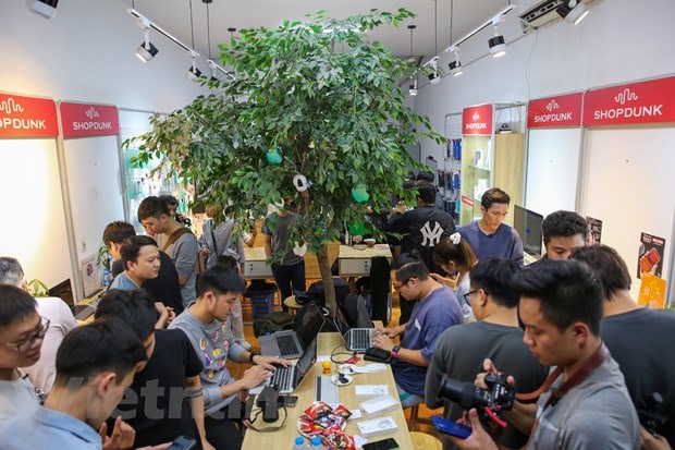 Rất đông người hâm mộ Apple đã có mặt tại một cửa hàng di động trên phố Cầu Giấy, Hà Nội để trải nghiệm những chiếc ịPhone 12 đầu tiên về Việt Nam. (Ảnh: Minh Sơn/Vietnam+)