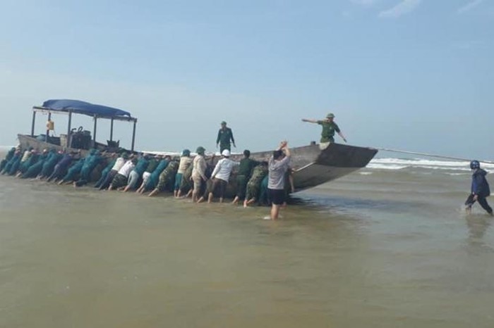Đồn Biên phòng Cửa Tùng và lực lượng dân quân các xã Vĩnh Tú, Vĩnh Thái, huyện Vĩnh Linh đưa tàu vào bờ để neo đậu. Ảnh: CĐ.