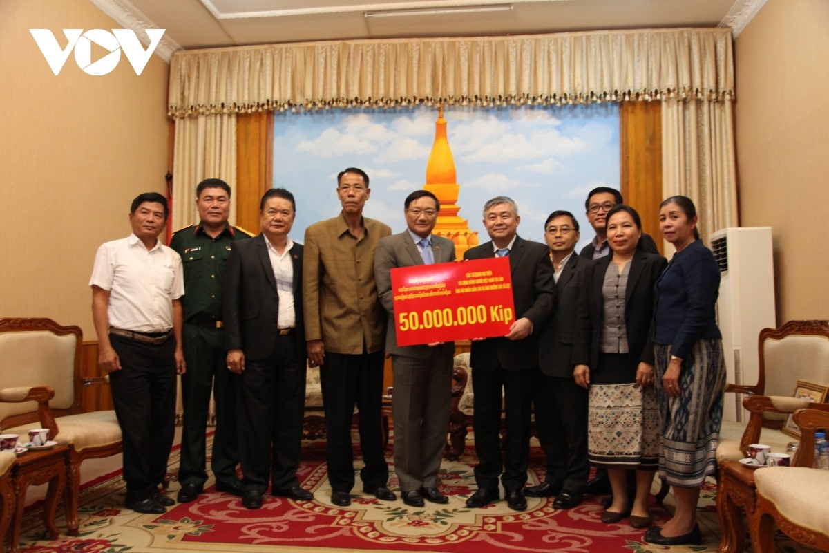 Đại sứ Nguyễn Bá Hùng trao tượng trưng số tiền 50 triệu kip cho Thứ trưởng Bộ Lao động và Phúc lợi xã hội Lào Padeumphone Sonthany.
