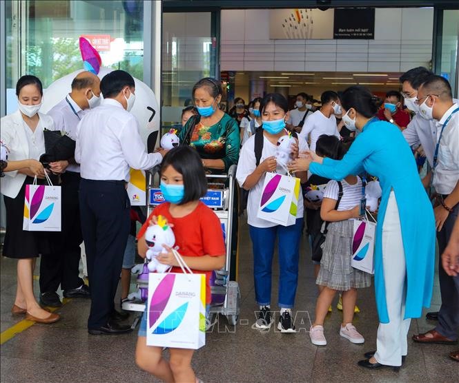 Những vị khách đầu tiên của đoàn 55 du khách đặt chân đến Sân bay quốc tế Đà Nẵng và nhận quà của đại diện ngành Du lịch thành phố. Ảnh: Báo Đà Nẵng.
