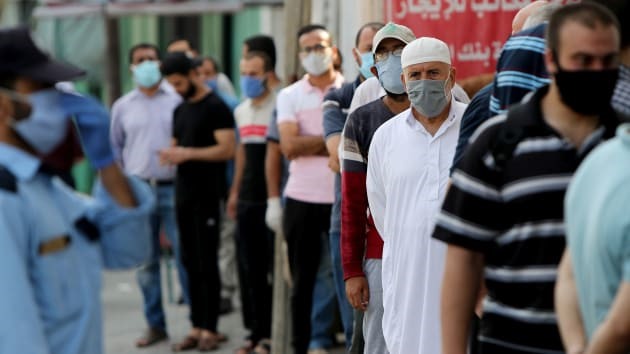 Các công chức Palestine xếp hàng chờ nhận lương bên ngoài ngân hàng trong thời gian bị phong toả sau khi dịch bệnh COVID-19 bùng phát tại Thành phố Gaza ngày 1/9. Ảnh: Reuters.
