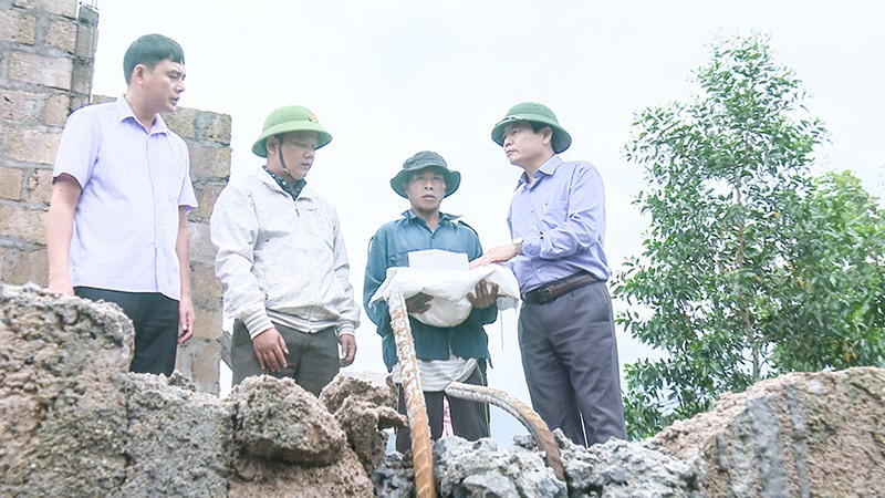 Bí thư Huyện ủy Đakrông Nguyễn Trí Tuân (bên phải) trao quà hỗ trợ người dân xã Tà Rụt bị thiệt hại do lũ lụt - Ảnh: VĂN TIẾN​