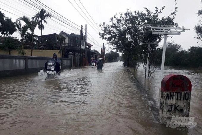 Người dân di chuyển trên tuyến đường ngập lụt ở huyện Hải Lăng chiều 11/11. Ảnh: CĐ.