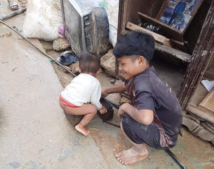 Hai em nhỏ ở xã Phước Thành bên những gì còn sót lại sau trận lũ quét.