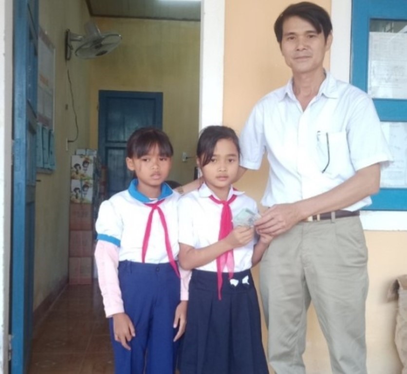 2 em  Hồ Thị Khuê và Hồ Thị Thanh Hoài trao lại số tiền tìm thấy để nhà trường trả lại cho người để quên​- Ảnh: NĐ