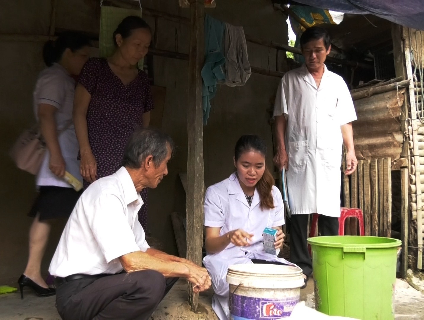 Cán bộ y tế Triệu Phong hướng dẫn người dân xử lý nước sạch sau lũ