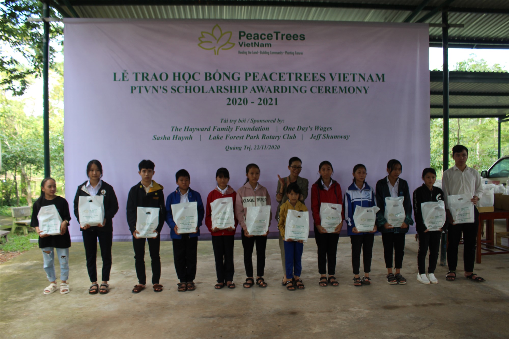 Đại diện Tổ chức Cây hòa bình Việt Nam trao học bổng cho các em học sinh nghèo hiếu học  - Ảnh: H.T
