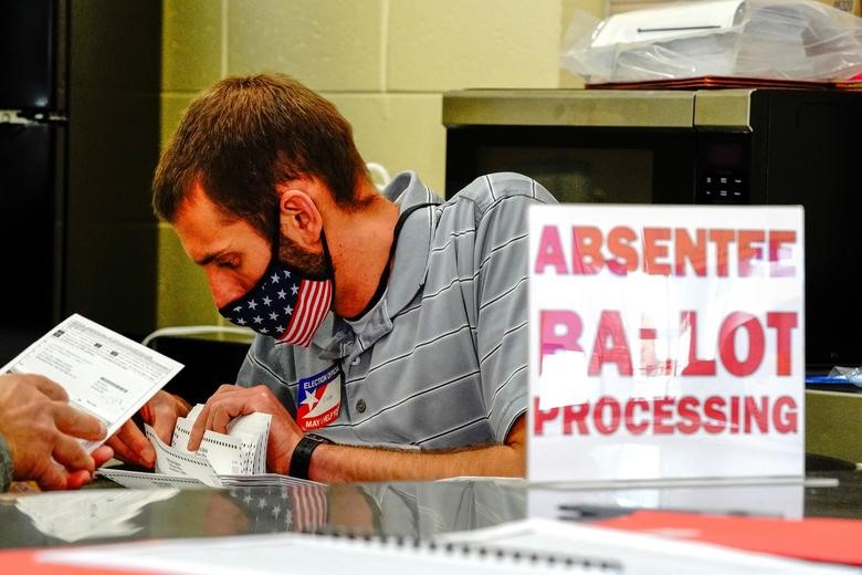 Một quan chức xử lý lá phiếu vắng mặt bị trùng lặp tại điểm kiểm phiếu ở Waukesha, Wisconsin. Ảnh: Reuters