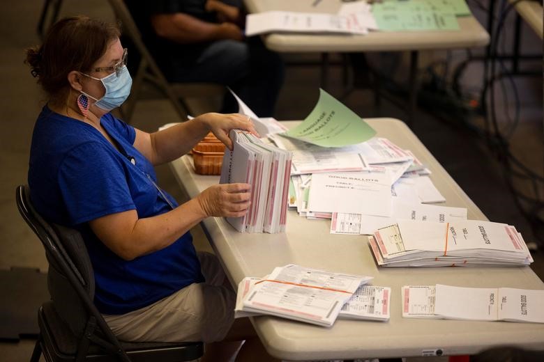 Nhân viên bầu cử sắp xếp thông qua một số trong số hàng nghìn lá phiếu gửi qua thư tại Cơ quan đăng ký cử tri quận Cam ở Santa Ana, California, ngày 2/11. Ảnh: Reuters