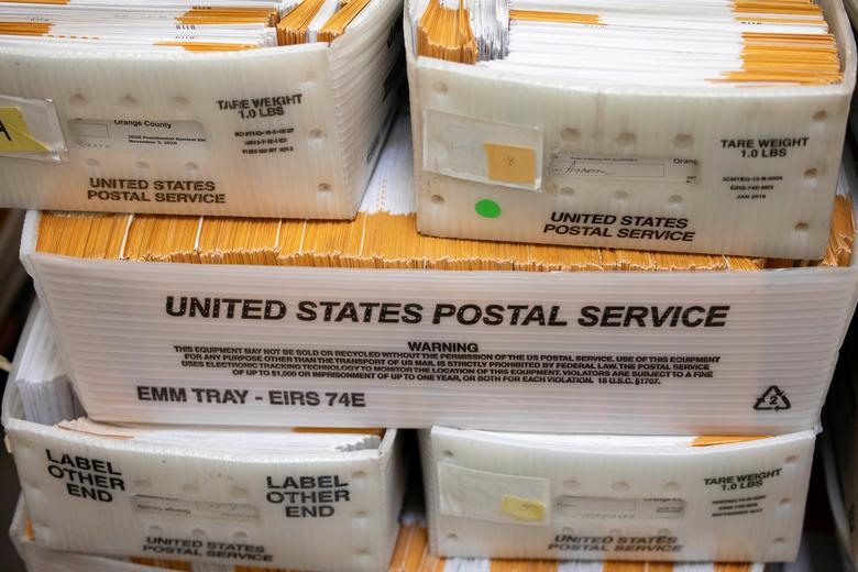 Một số trong số hàng ngàn lá phiếu gửi bằng thư nằm trong hộp Bưu điện Mỹ chờ được xử lý tại Cơ quan đăng ký cử tri Quận Cam ở Santa Ana, California. Ảnh: Reuters