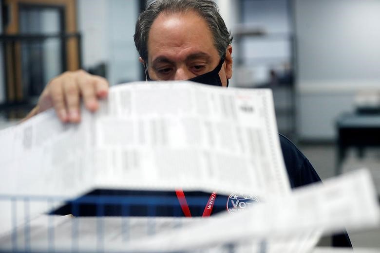 Một thành viên của ban kiểm duyệt Hạt Pinellas xử lý các lá phiếu vào ngày bầu cử ở Largo, Florida. Ảnh: Reuters
