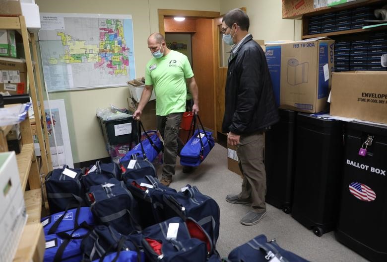 Các quan chức bầu cử chuyển các túi phiếu đến cơ sở kiểm phiếu trung tâm vào ngày bầu cử ở Kenosha, Wisconsin. Ảnh: Reuters