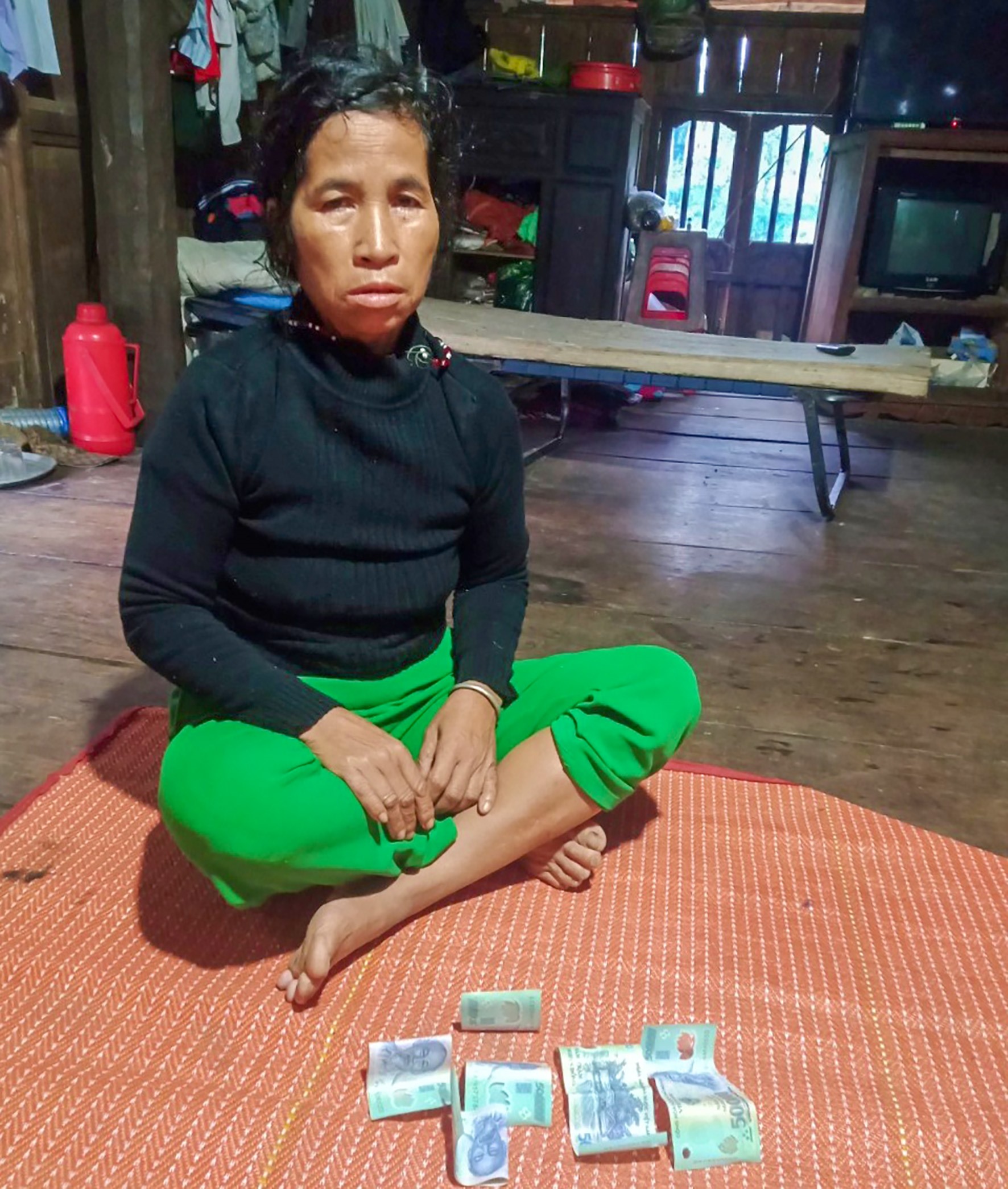 Bà Hồ Thị Phing và số tiền vừa phát hiện trong áo quần cũ được tặng - Ảnh: NVCC