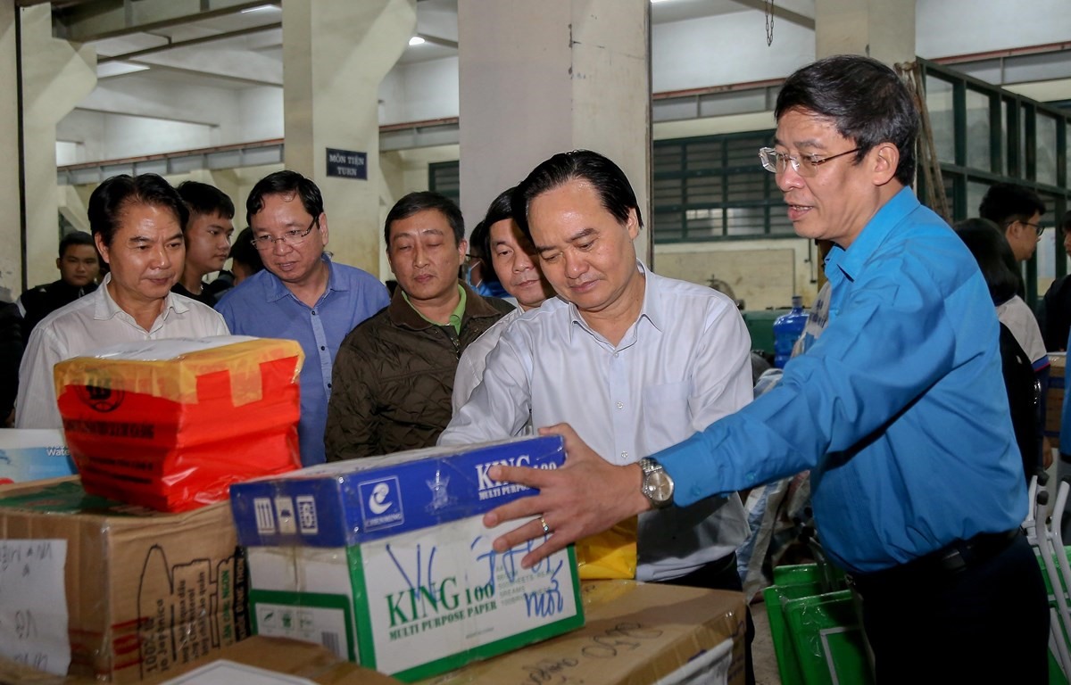 Bộ trưởng Phùng Xuân Nhạ (thứ hai từ phải sang) tham gia hỗ trợ vận chuyển hàng đến học sinh miền Trung. (Ảnh: PV)