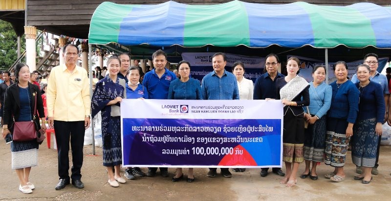 Đại diện LaoVietBank trao ủng hộ người dân lũ lụt tại tỉnh Savannakhet, miền trung Lào với sự chứng kiến của Chủ tịch Quốc hội Lào Pany Yathotou.