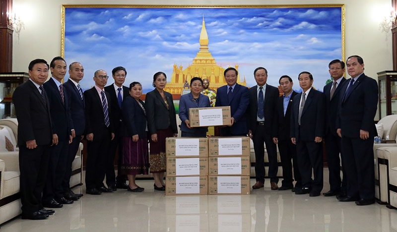 Đại sứ Nguyễn Bá Hùng (phải) trao 30 nghìn khẩu trang của Ban Đối ngoại T.Ư Đảng tặng các ban Đảng T.Ư của Đảng NDCM Lào, chiều 6-11.