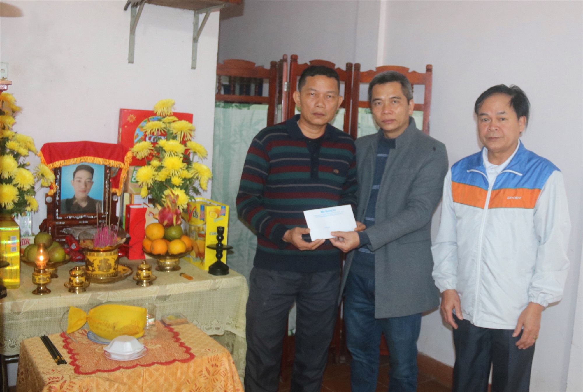 Đại diện Báo Quảng Trị trao tiền hỗ trợ cho gia đình công nhân Bùi Đức Thọ - Ảnh: N.B