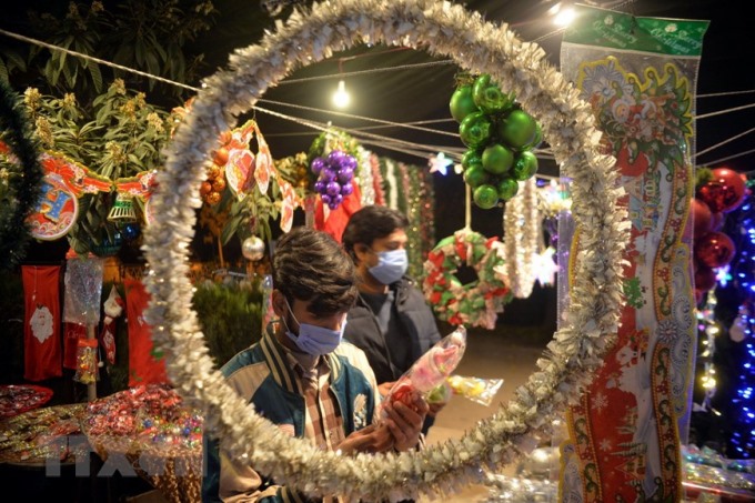 Người dân chọn mua đồ trang trí Giáng sinh tại Peshawar, Pakistan. (Ảnh: THX/TTXVN)