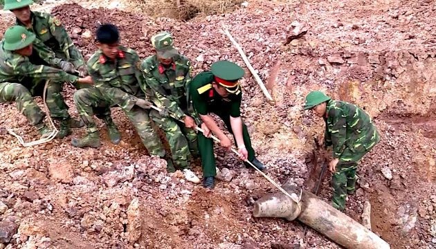 Lực lượng công binh Quảng Trị đang kéo quả bom lên khỏi mặt đất - Ảnh: NCH