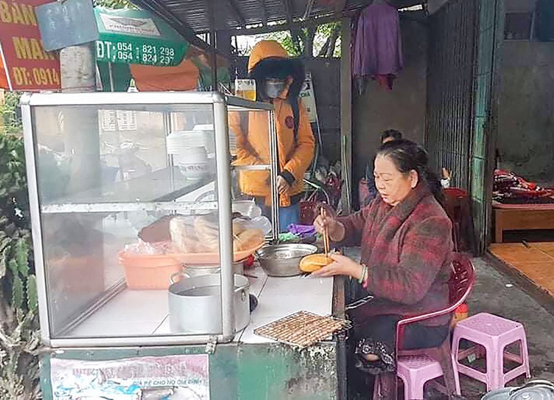 Mặc dù khiếm khuyết đôi chân nhưng bà Lục vẫn tự mình kiếm sống bằng nghề bán bánh mì - Ảnh: H.T​