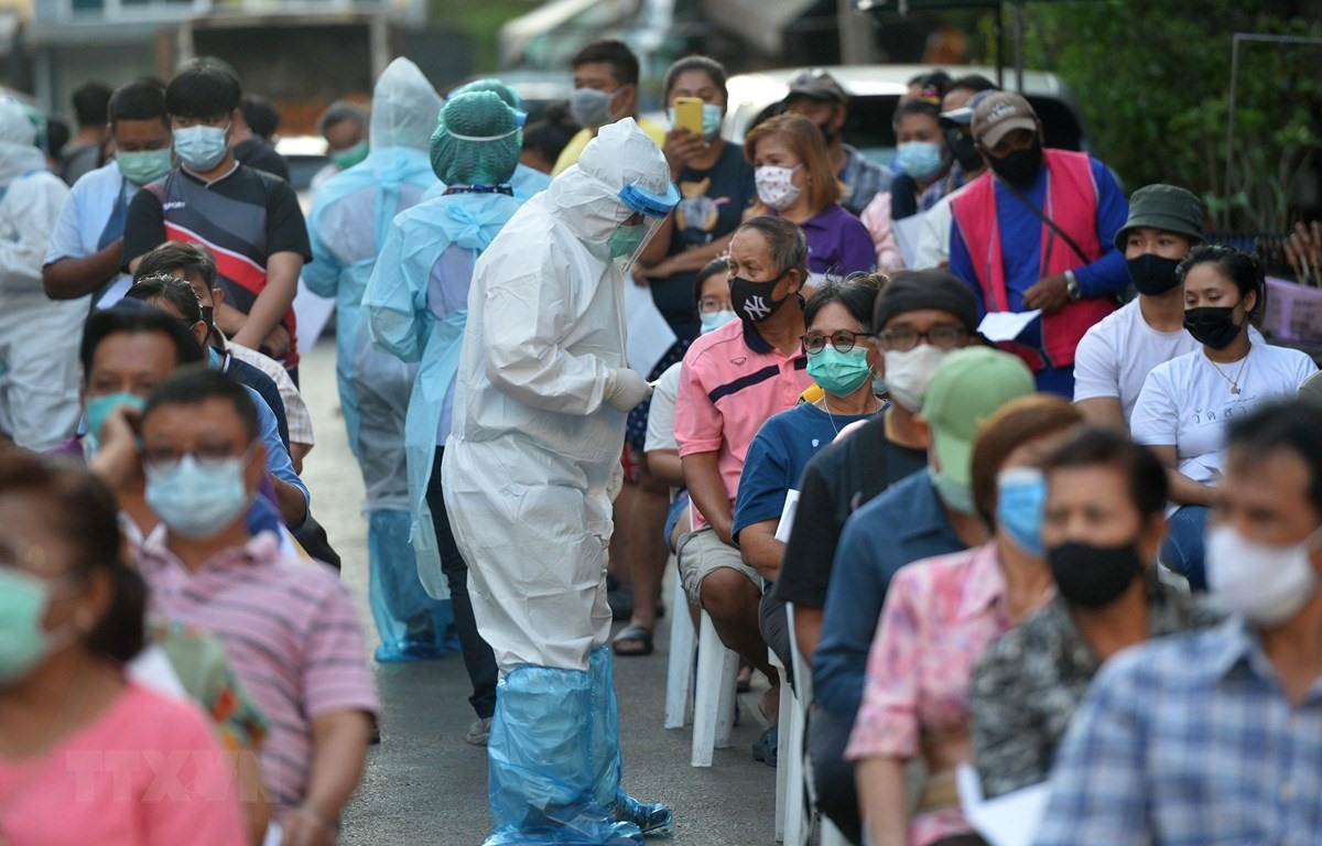 Nhân viên y tế lấy mẫu xét nghiệm COVID-19 cho người dân tại Samut Sakhon, Thái Lan. (Ảnh: AFP/TTXVN)