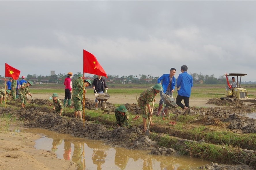 Các lực lượng hỗ trợ người dân cải tạo ruộng đồng sau mưa lũ tại tỉnh Quảng Trị. Ảnh: XD