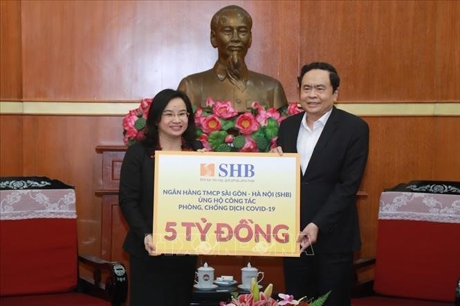 Chủ tịch Ủy ban Trung ương MTTQ Việt Nam Trần Thanh Mẫn tiếp nhận ủng hộ của Ngân hàng TMCP Sài Gòn - Hà Nội (SHB). Ảnh: TTXVN phát