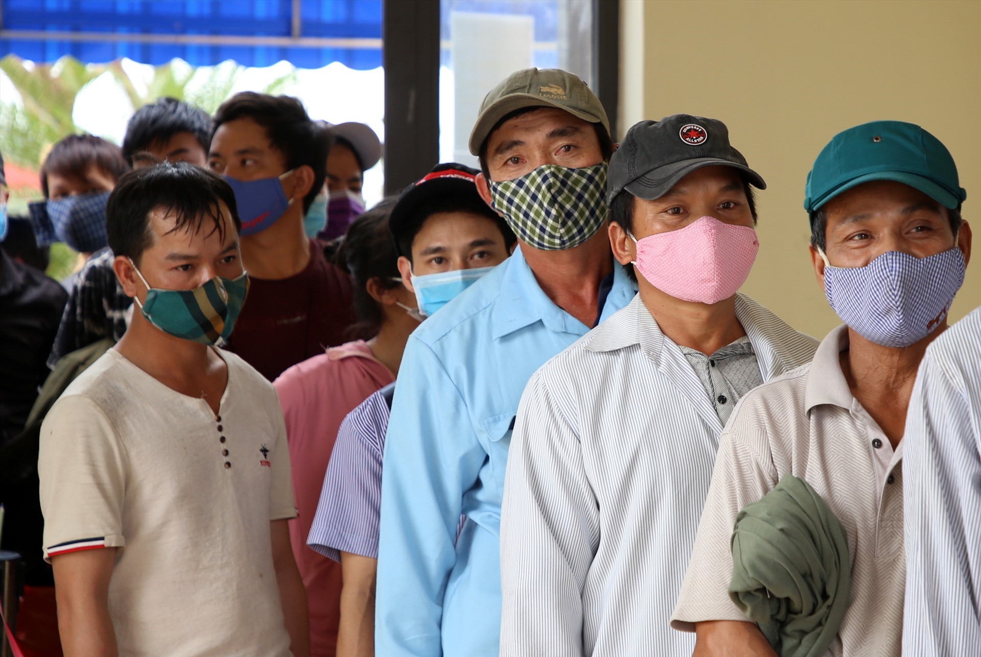 Những người đàn ông này làm việc ở Lào, nhưng trước thông tin dịch COVID-19 diễn biến phức tạp, họ đã trở về quê. Dù phải xếp hàng đợi làm thủ tục khá lâu, nhưng ai cũng chấp hành, vui mừng vì được về quê nhà an toàn.