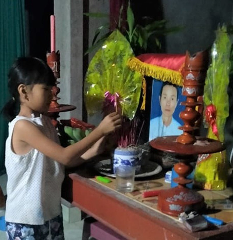 Em Dương Thị Thu Hiền thắp nén hương lên bàn thờ mẹ. Ảnh: TS