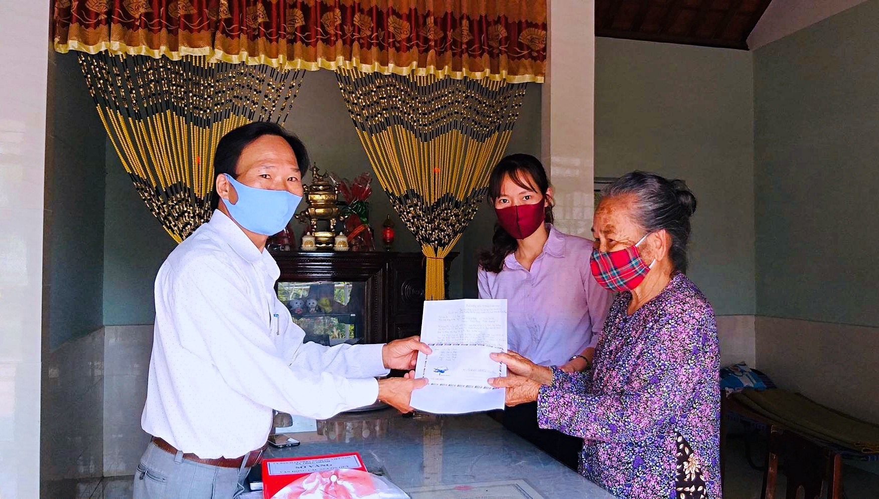 Bà Lê Thị Sen trao số tiền ủng hộ cho lãnh đạo UBMTTQ Việt Nam xã Triệu Thành - Ảnh: Q.H