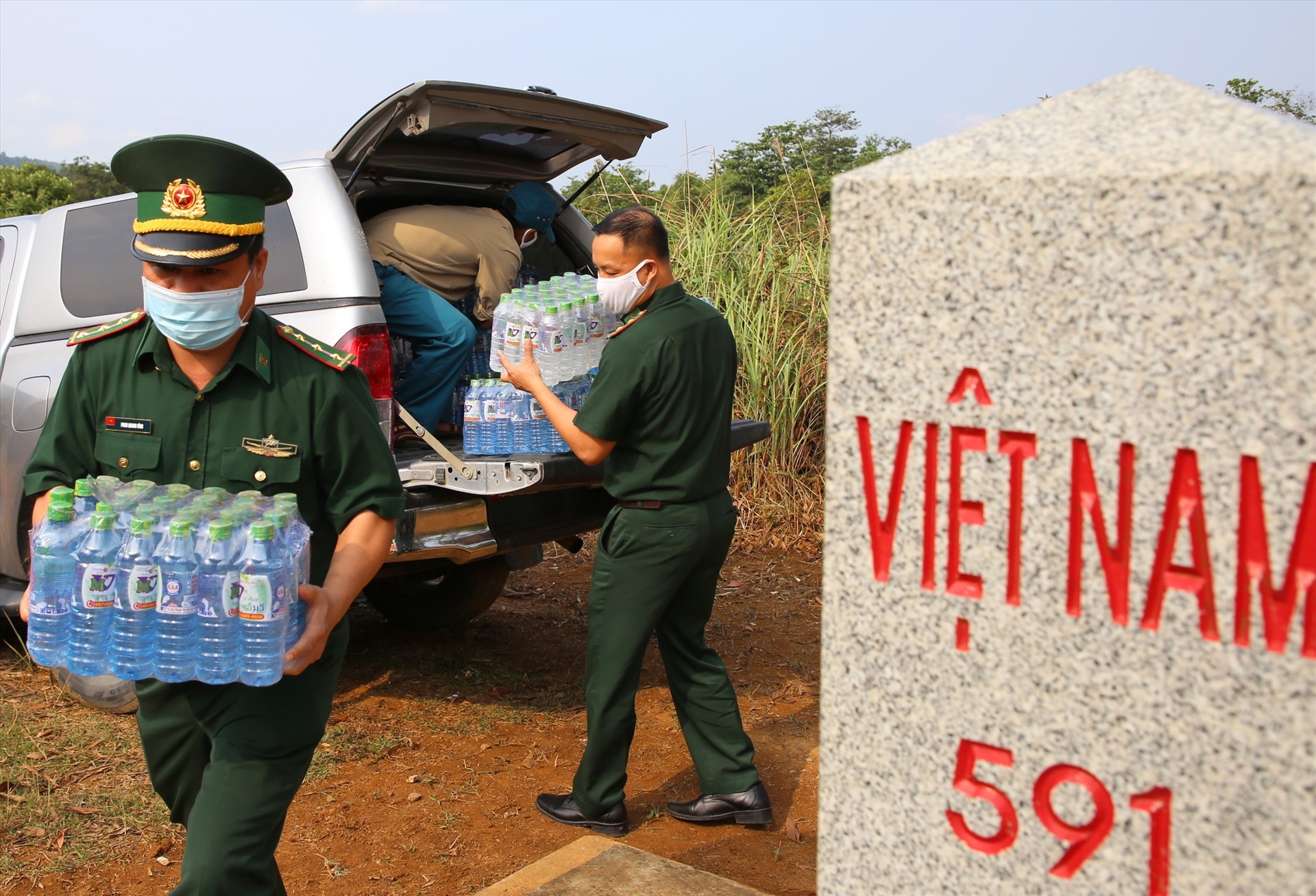 Vật tư y tế, gạo, và nước lọc được các cán bộ, chiến sĩ Biên phòng Hướng Lập vận chuyển đến cột mốc, để trao cho các lực lượng và người dân Lào.