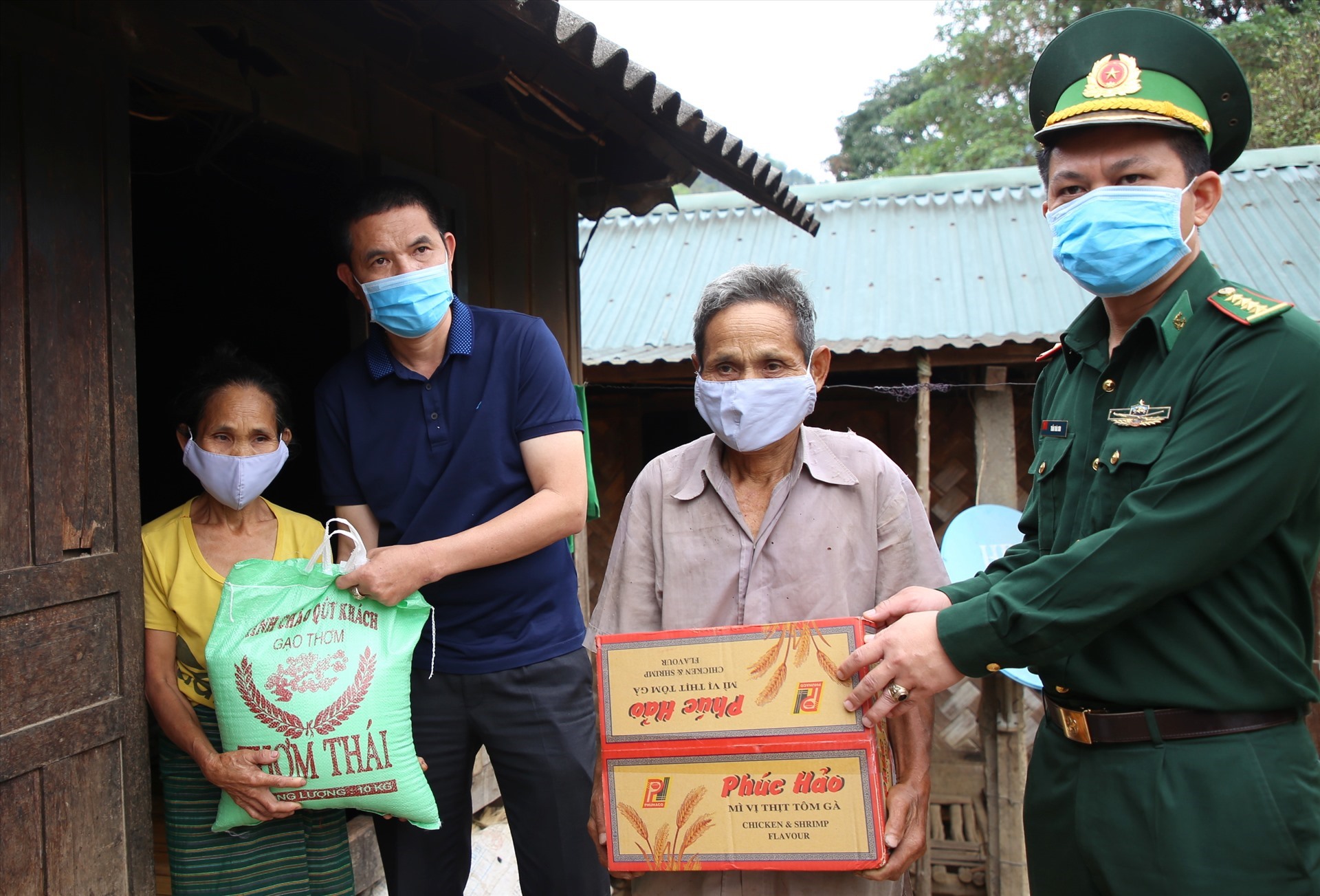 Đại diện Quỹ TLV Lao Động và lãnh đạo Đồn Biên phòng Hướng Lập trao gạo và mì tôm cho người dân ở bản Cù Bai. Ảnh: Hưng Thơ.