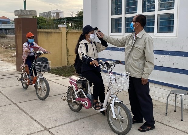 Các em học sinh Trường trung học cơ sở Nguyễn Bỉnh Khiêm, ở xã Phước Nam, huyện Thuận Nam, Ninh Thuận được kiểm tra thân nhiệt trước khi vào lớp học. (Ảnh: Công Thử/TTXVN)