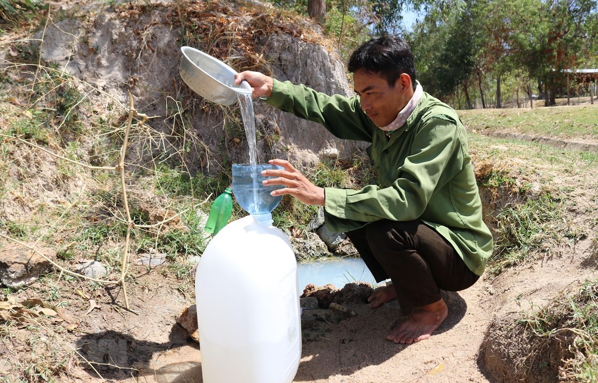 Người dân xã Công Hải (huyện Thuận Bắc, Ninh Thuận) múc nước từ giếng dã chiến đem về dùng cho sinh hoạt hàng ngày. (Ảnh: Nguyễn Thành/TTXVN)