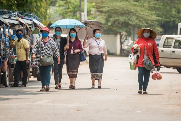 Người dân đeo khẩu trang phòng lây nhiễm COVID-19 tại Vientiane của Lào. (Ảnh: THX/TTXVN)