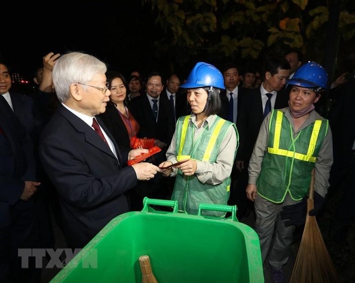 Tổng Bí thư, Chủ tịch nước Nguyễn Phú Trọng thăm hỏi, tặng quà công nhân môi trường đang làm việc đêm giao thừa Tết Nguyên đán Kỷ Hợi 2019 tại khu vực Hồ Hoàn Kiếm. Ảnh : Trí Dũng/TTXVN)