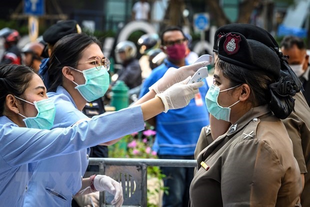 Nhân viên y tế kiểm tra thân nhiệt cho cảnh sát ở Bangkok, Thái Lan. (Nguồn: AFP/TTXVN)