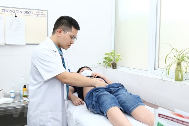 Các bác sỹ Bệnh viện Hữu nghị Việt Đức khám cho bệnh nhi. (Ảnh: PV/Vietnam+)