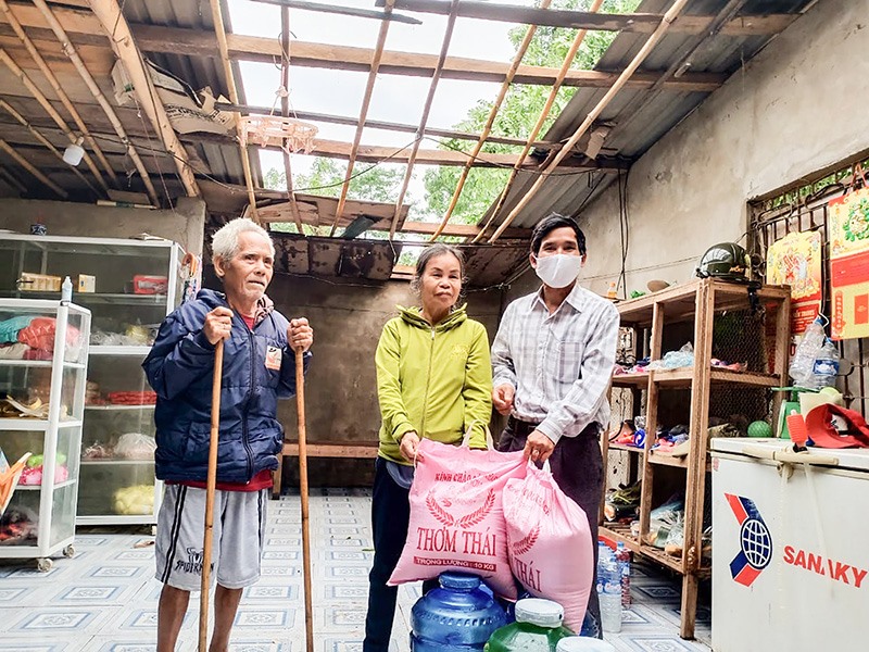Anh Hồ Văn Bền (bên phải) trao quà động viên hộ gia đình đồng bào dân tộc thiểu số bị ảnh hưởng bởi thiên tai. Ảnh: TL