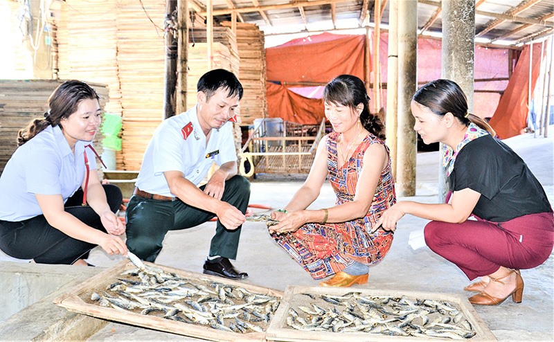 Cán bộ Chi cục Quản lý chất lượng nông lâm sản và thủy sản tỉnh kiểm tra mẫu cá tại lò hấp sấy cá của chị Võ Thị Hồng. Ảnh: HTS